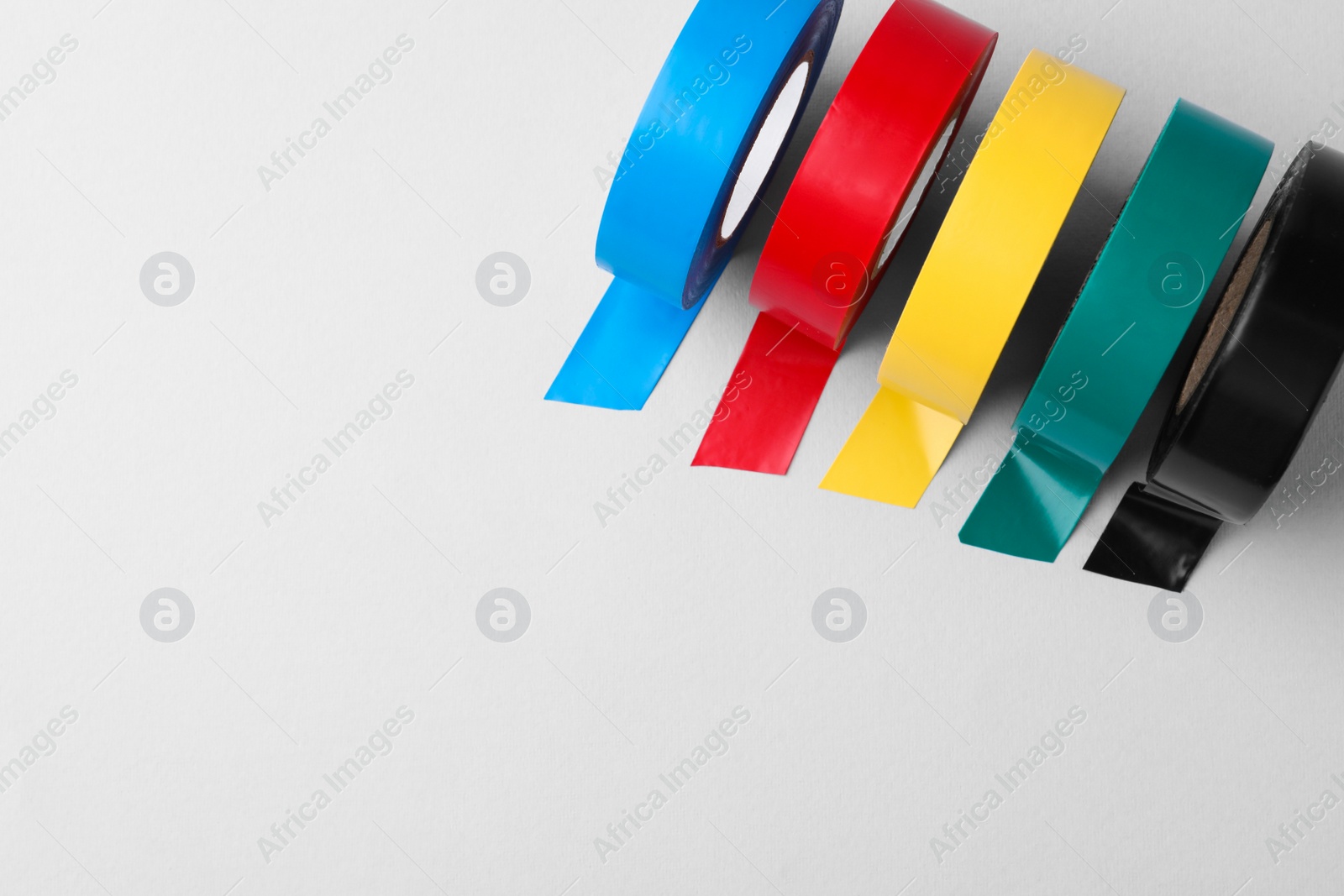 Photo of Colorful insulating tapes on white background, flat lay. Space for text