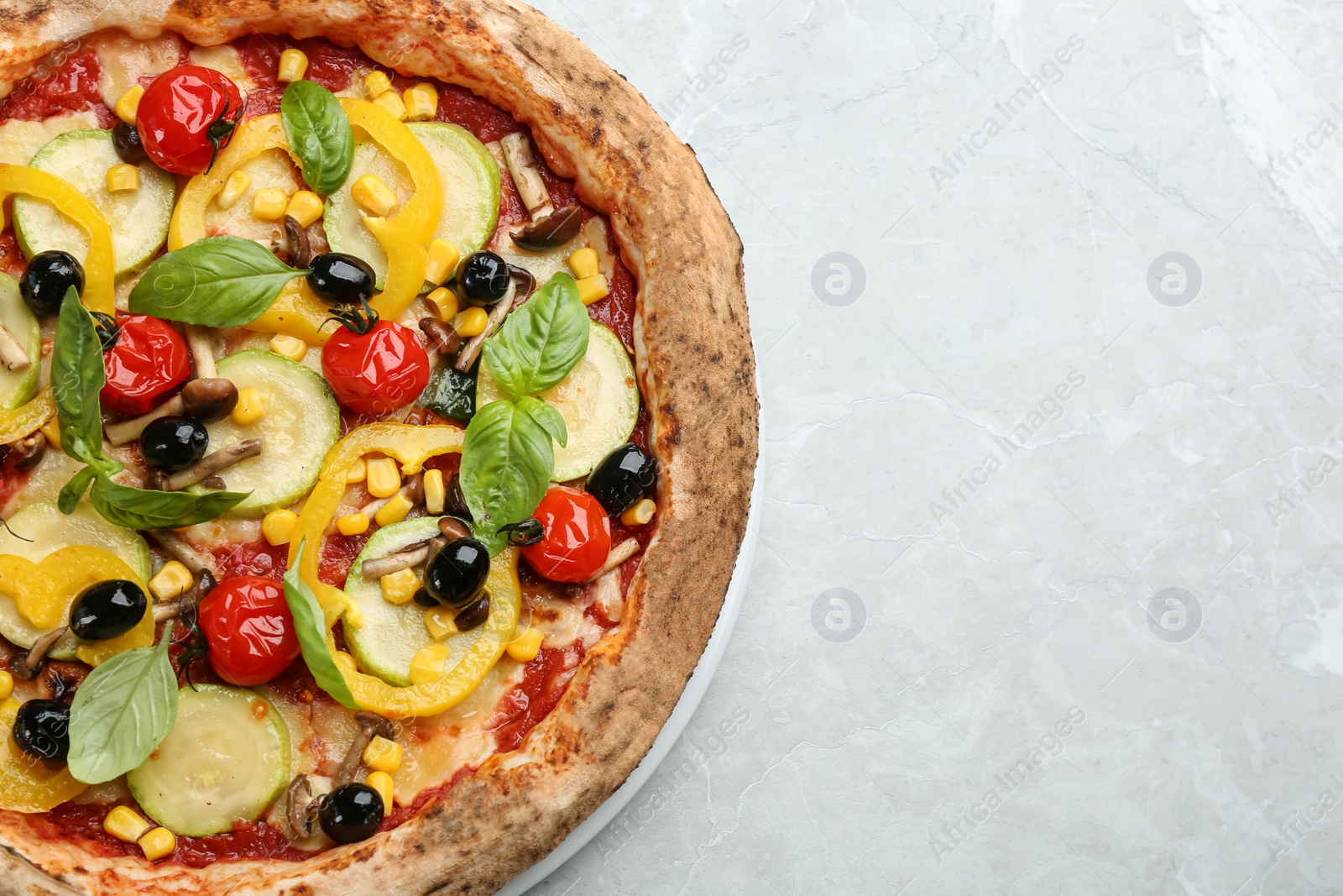 Photo of Tasty vegetable pizza on light grey table, top view. Space for text