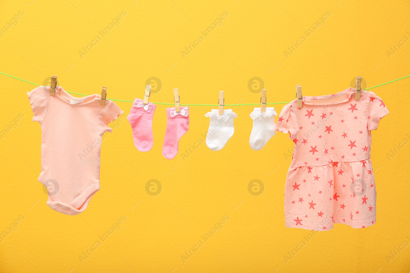 Photo of Children's clothes on laundry line against color background