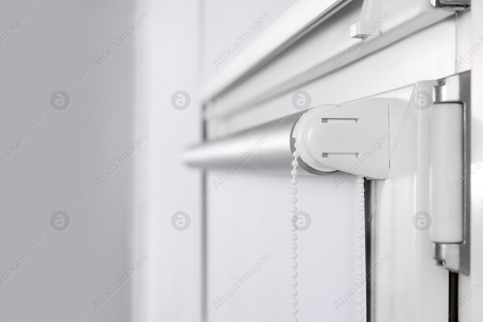 Photo of Window with white roller blind indoors, closeup