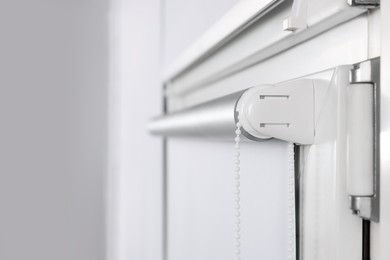 Photo of Window with white roller blind indoors, closeup