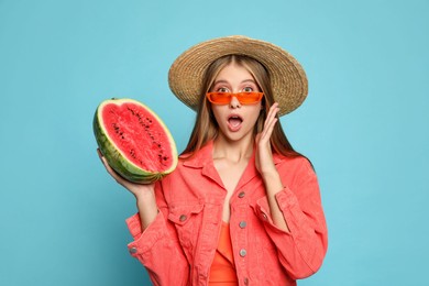 Photo of Beautiful girl with half of watermelon on light blue background