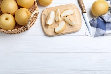 Photo of Cut and whole apple pears on white wooden table, flat lay. Space for text