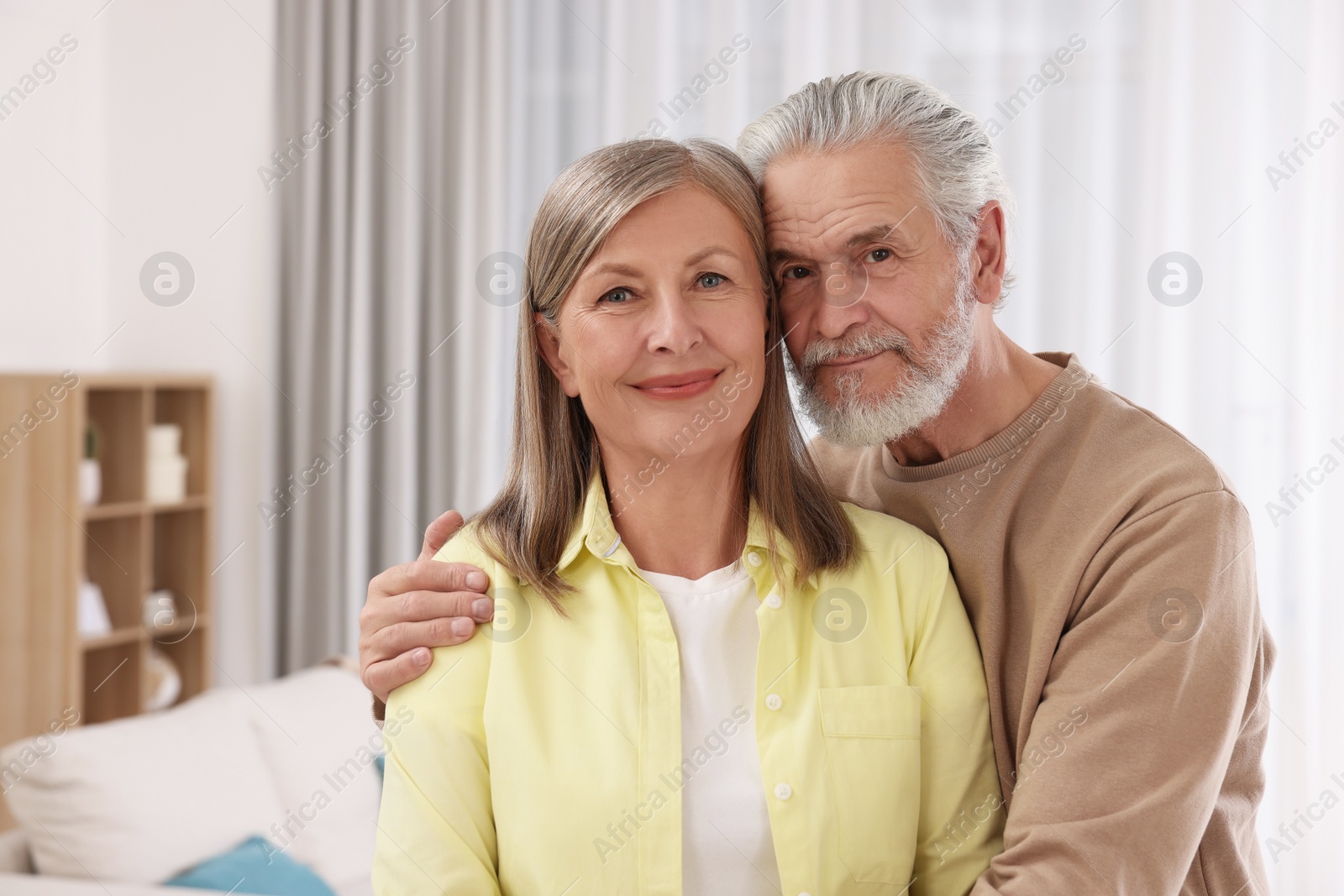 Photo of Portrait of affectionate senior couple at home. Space for text