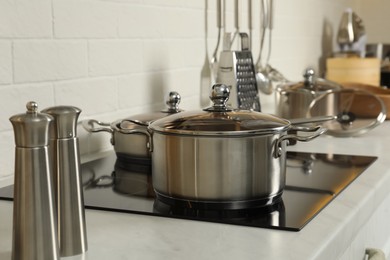 Pot and pan on electric stove in kitchen. Cooking utensils