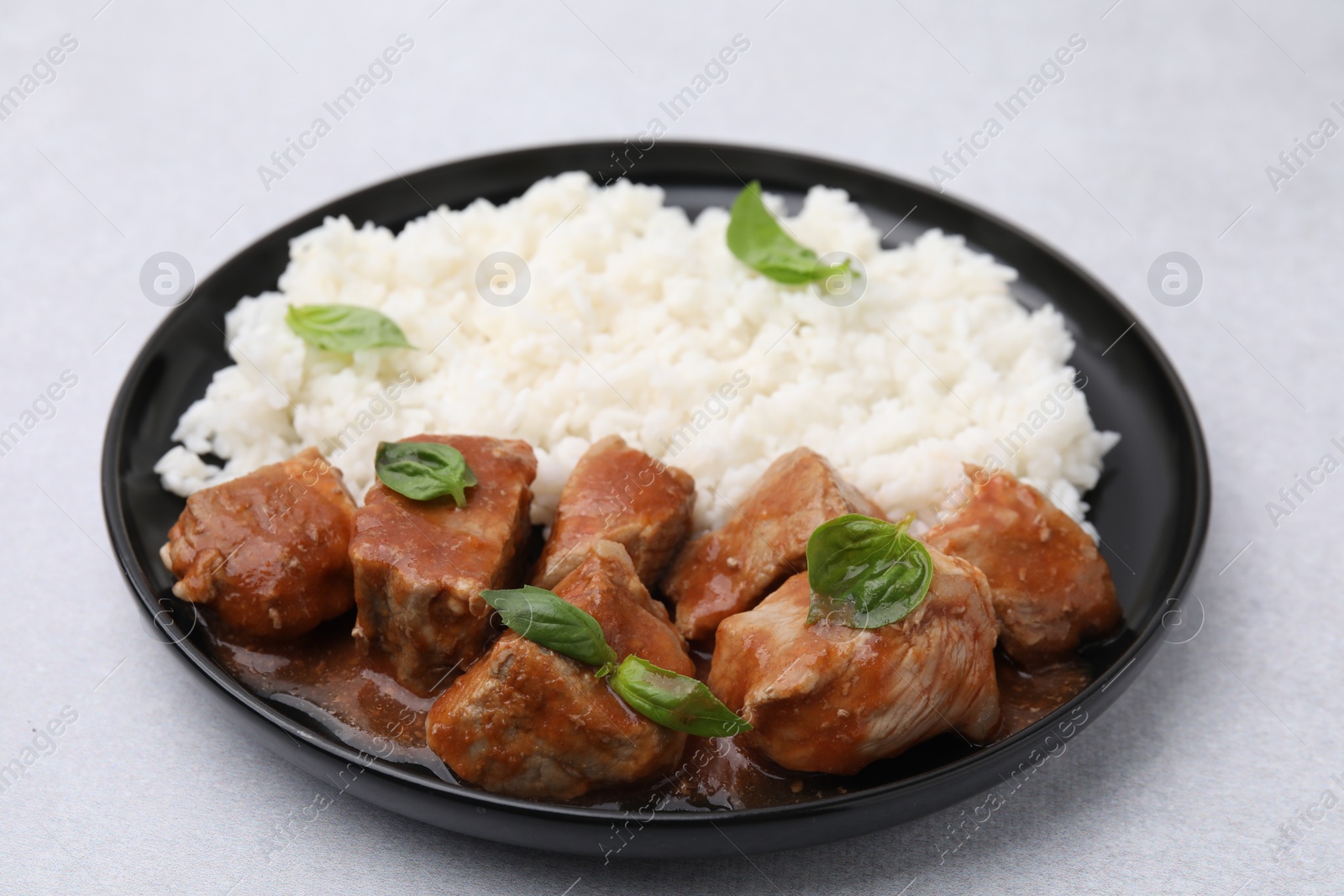 Photo of Delicious goulash with rice on light table, closeup