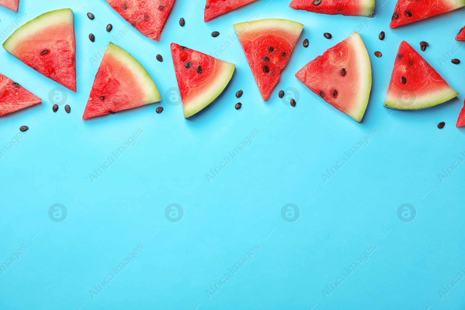 Photo of Slices of ripe watermelon on color background, top view with space for text