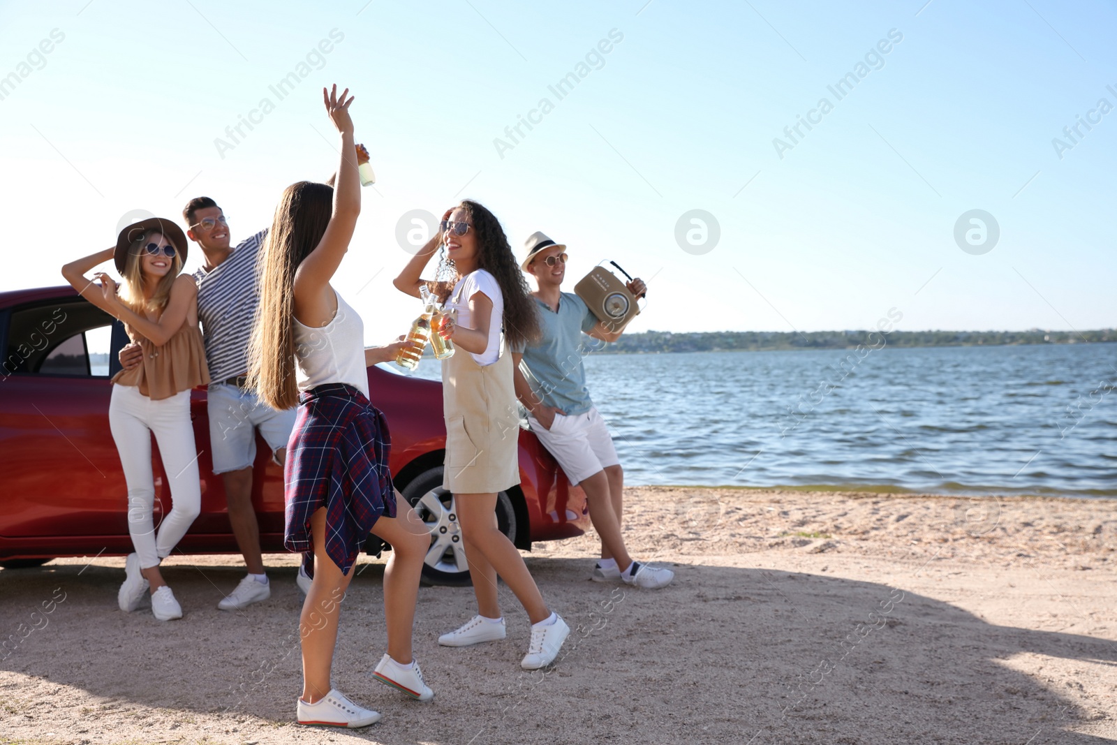 Photo of Happy friends having fun near car on beach. Summer trip