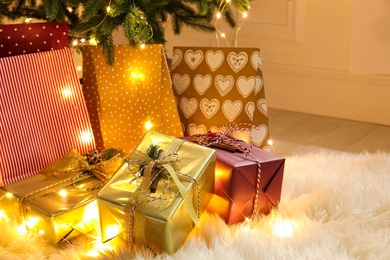 Photo of Many different gifts under Christmas tree indoors