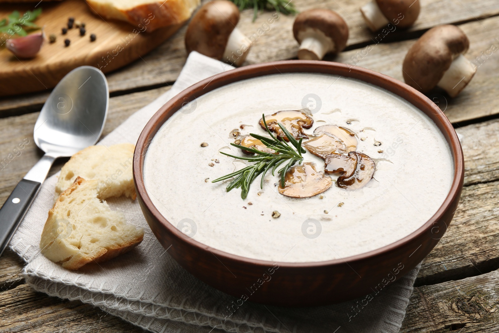 Photo of Fresh homemade mushroom soup served on wooden table, closeup