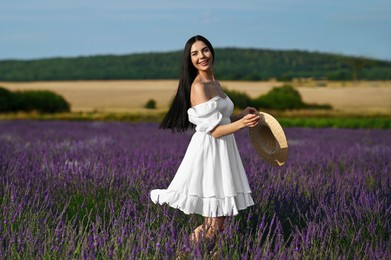 Photo of Beautiful young woman walking in lavender field