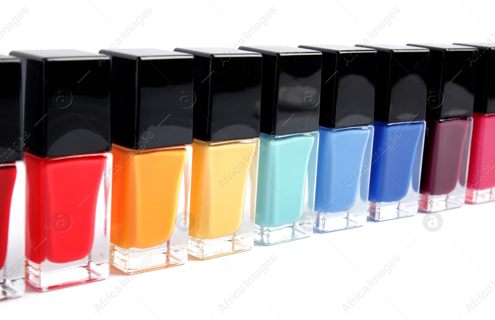 Photo of Bottles of nail polish on white background