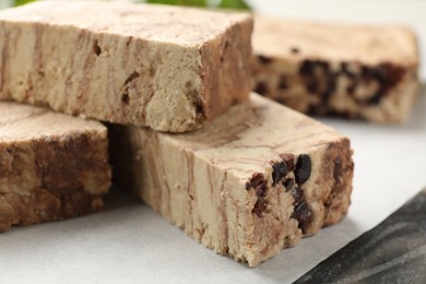 Photo of Pieces of tasty chocolate halva on table, closeup