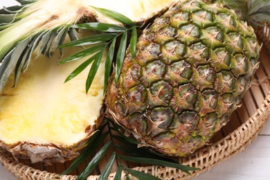 Photo of Whole and cut ripe pineapples on white wooden table