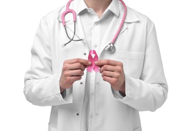 Mammologist with stethoscope giving pink ribbon on white background, closeup. Breast cancer awareness