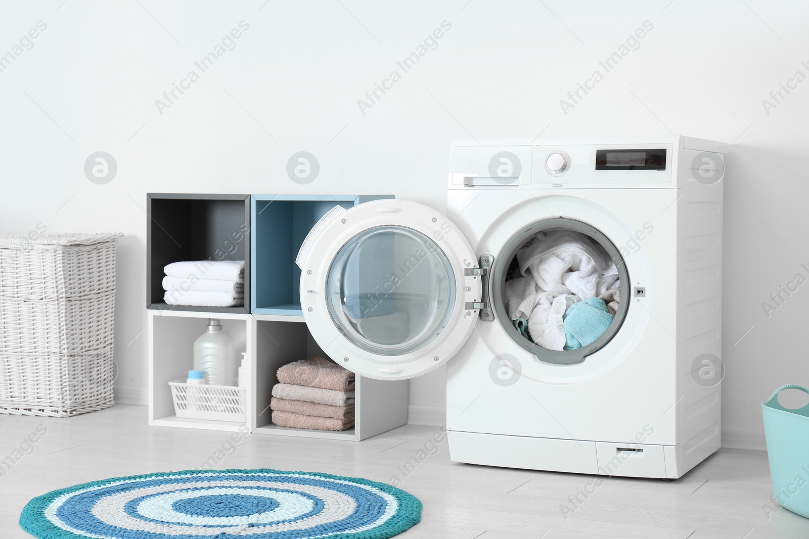 Photo of Crumpled towels in washing machine at home. Laundry room interior