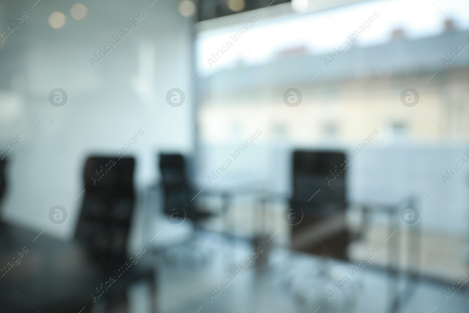 Photo of Blurred view of cozy workspaces with tables and chairs in office