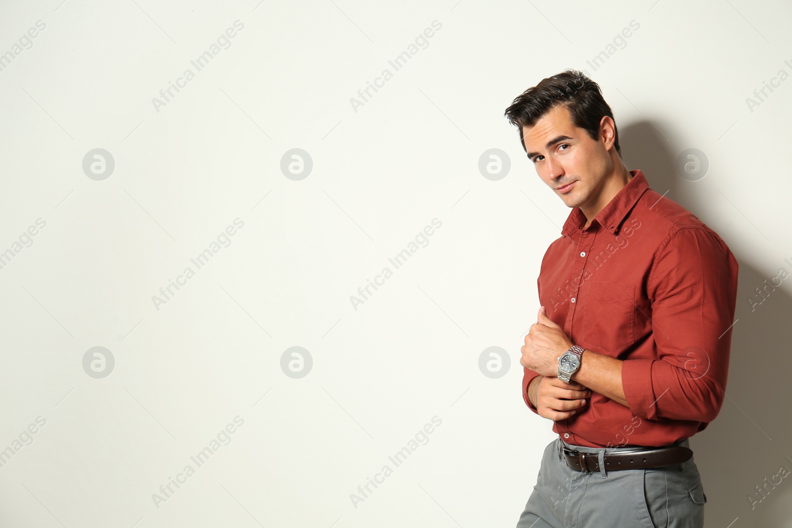 Photo of Handsome young man in stylish clothes on light beige background. Space for text