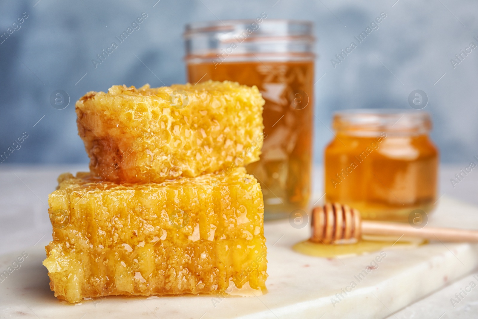 Photo of Fresh delicious honeycombs on white board, closeup