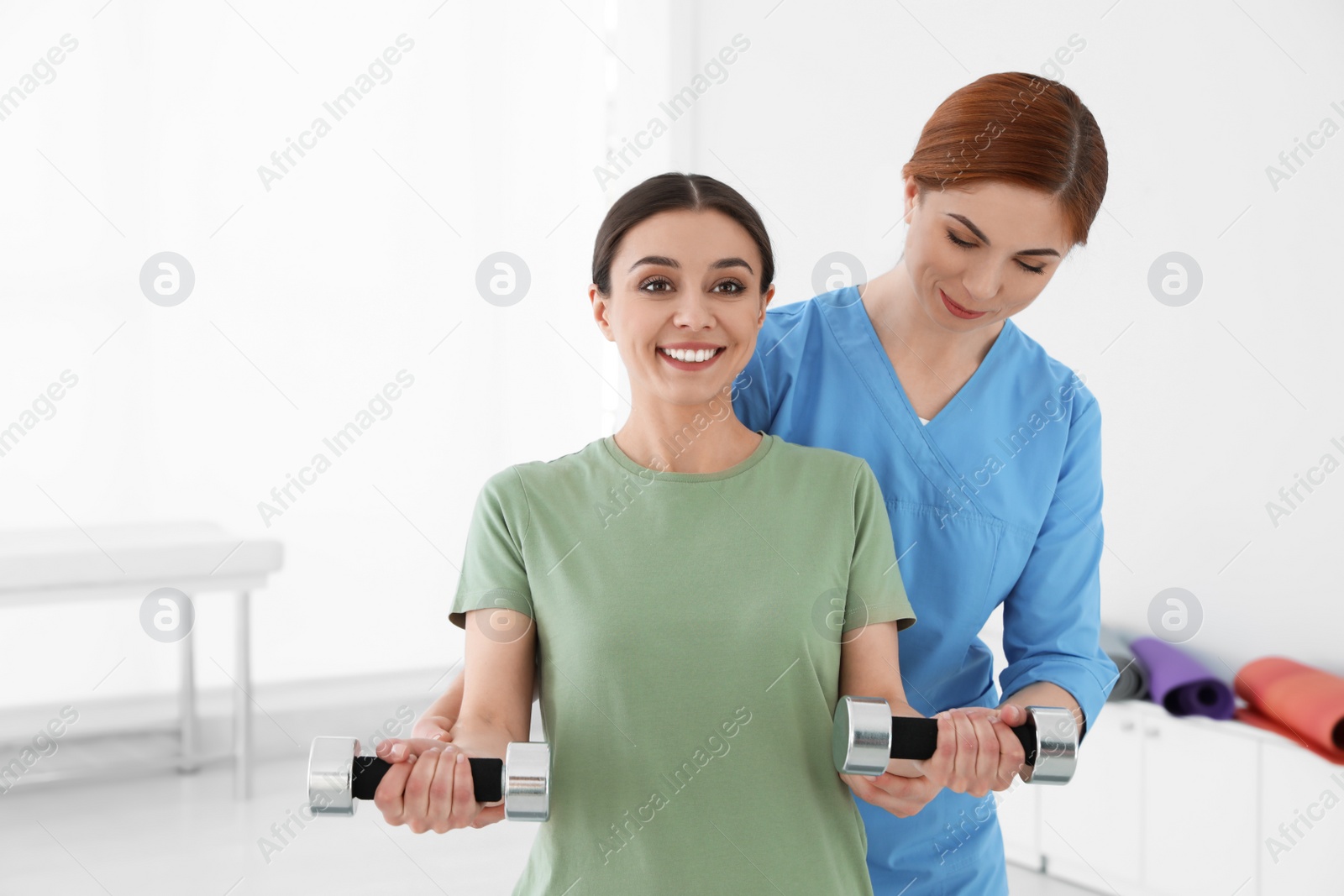 Photo of Professional physiotherapist working with female patient in rehabilitation center