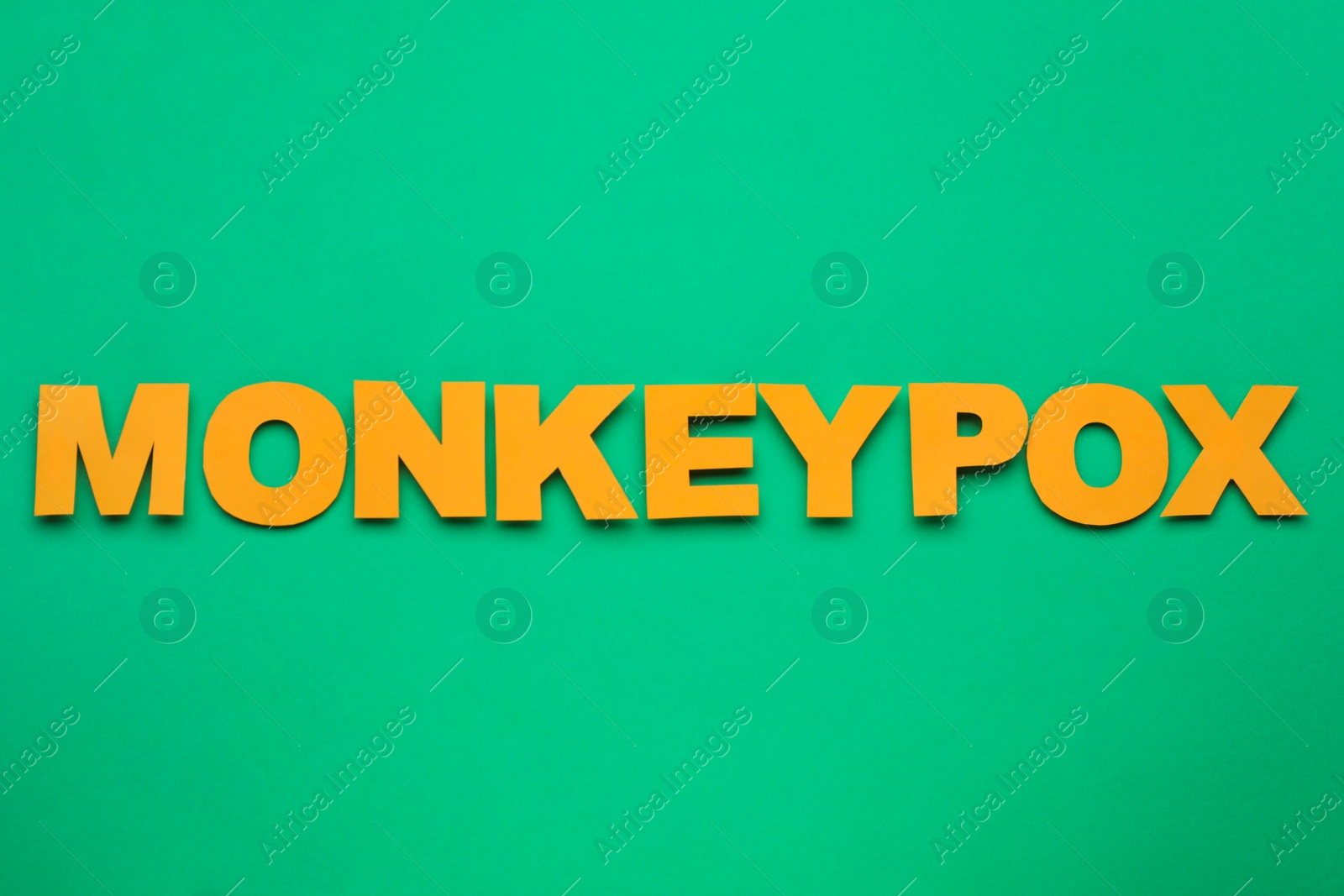 Photo of Word Monkeypox made of bright letters on green background, top view