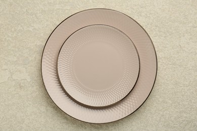 Beautiful ceramic plates on beige table, top view