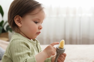 Photo of Cute baby girl with nibbler at home