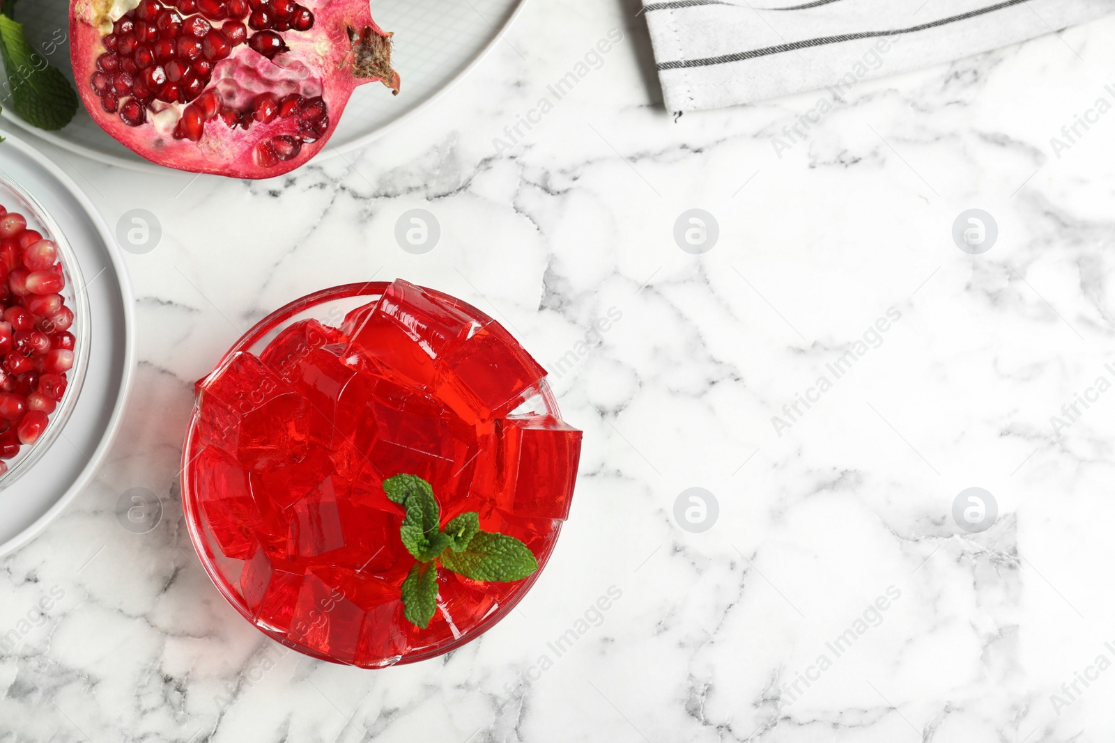 Photo of Flat lay composition with pomegranate jelly in bowl on marble table. Space for text