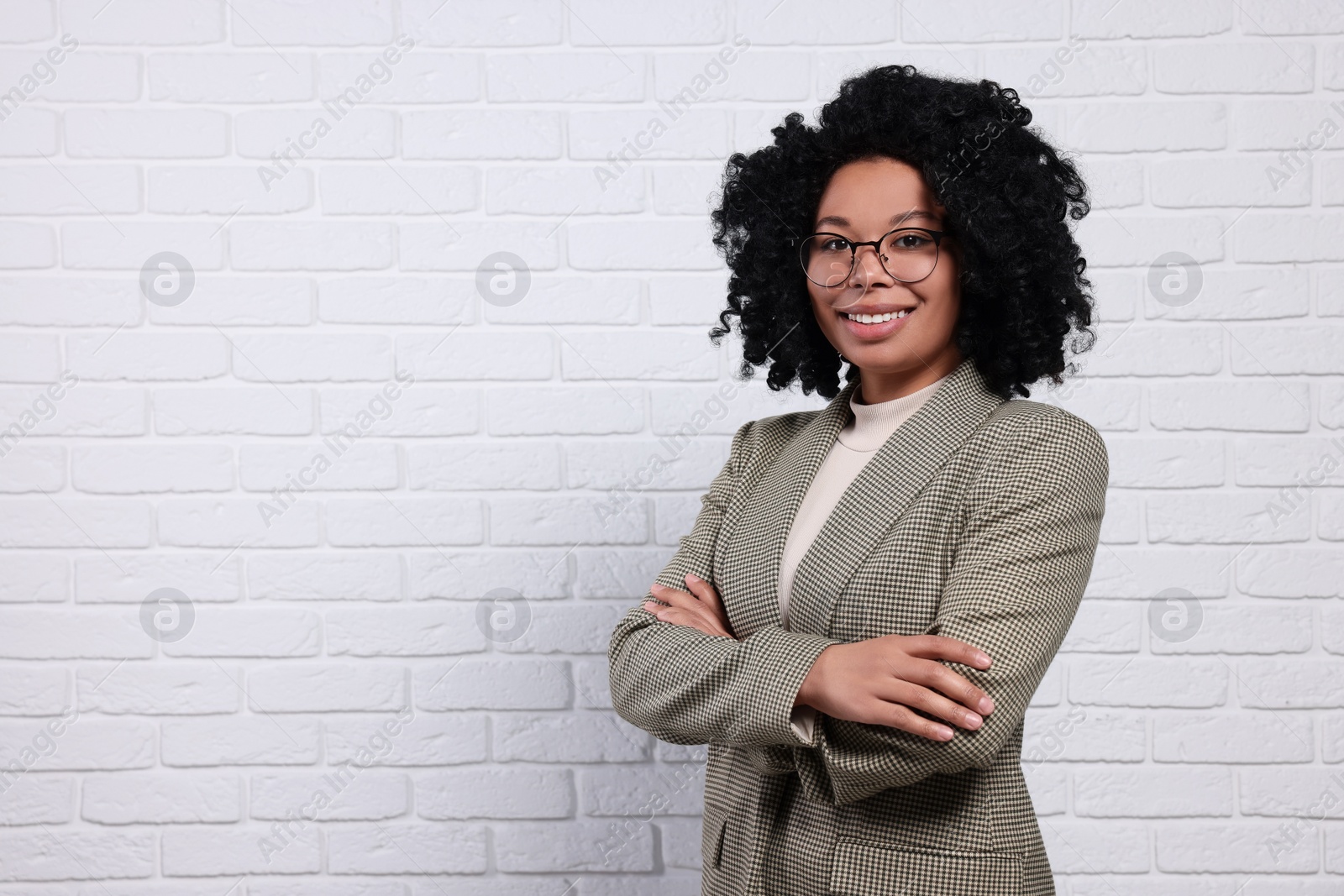 Photo of Young businesswoman in eyeglasses near white brick wall. Space for text