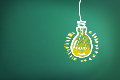 Image of Light bulb drawing as symbol of idea on green chalkboard