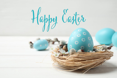 Image of Light blue egg in decorative nest and text Happy Easter on light background