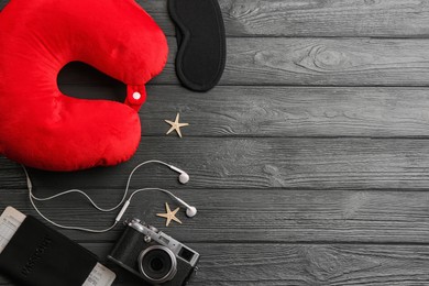 Flat lay composition with red travel pillow on wooden background, space for text