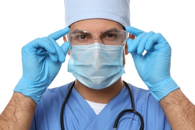 Doctor in protective mask, glasses and medical gloves against white background
