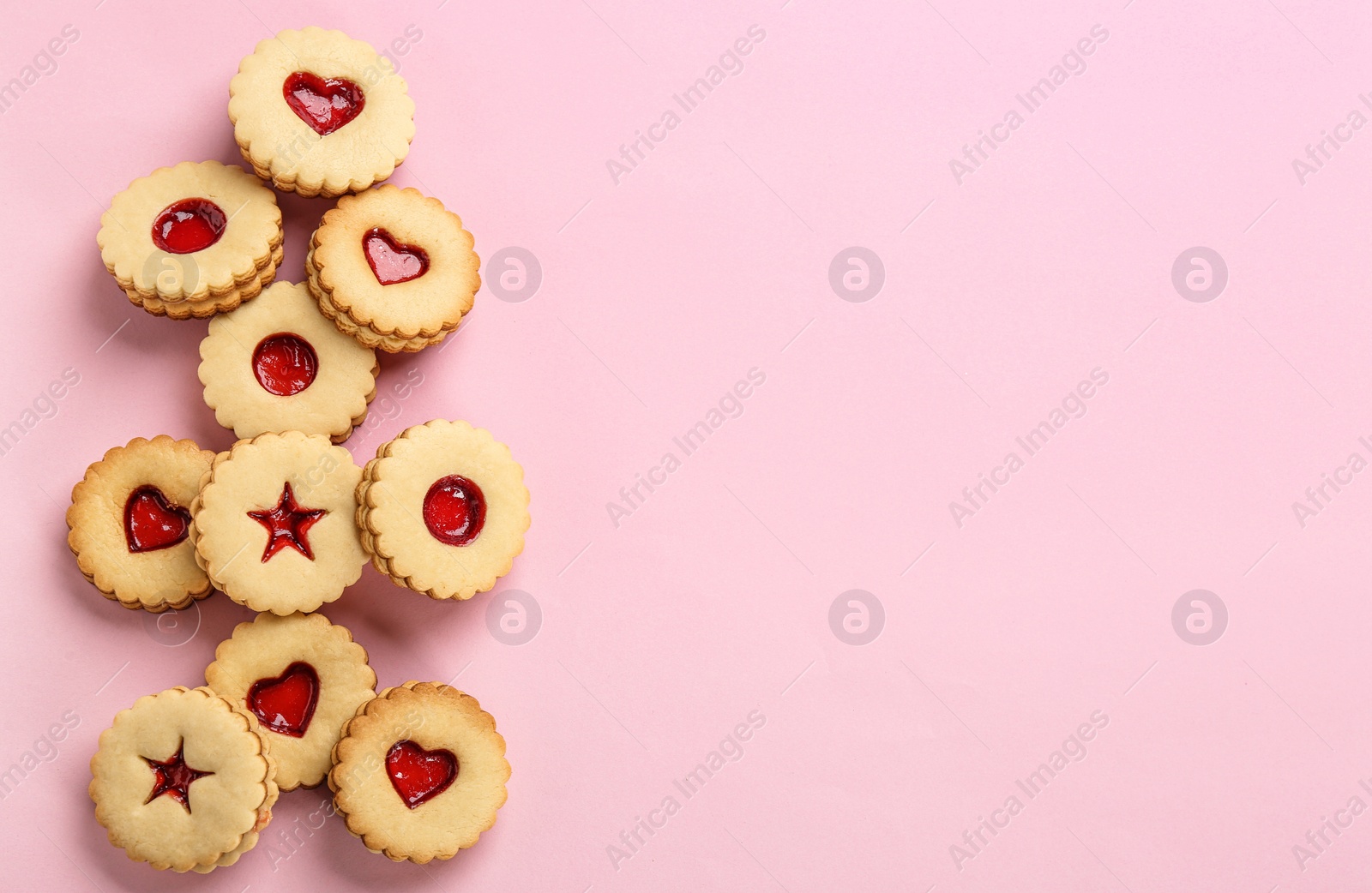 Photo of Traditional Christmas Linzer cookies with sweet jam on color background, top view