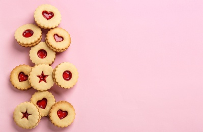 Photo of Traditional Christmas Linzer cookies with sweet jam on color background, top view