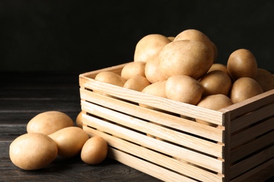 Raw fresh organic potatoes on wooden table