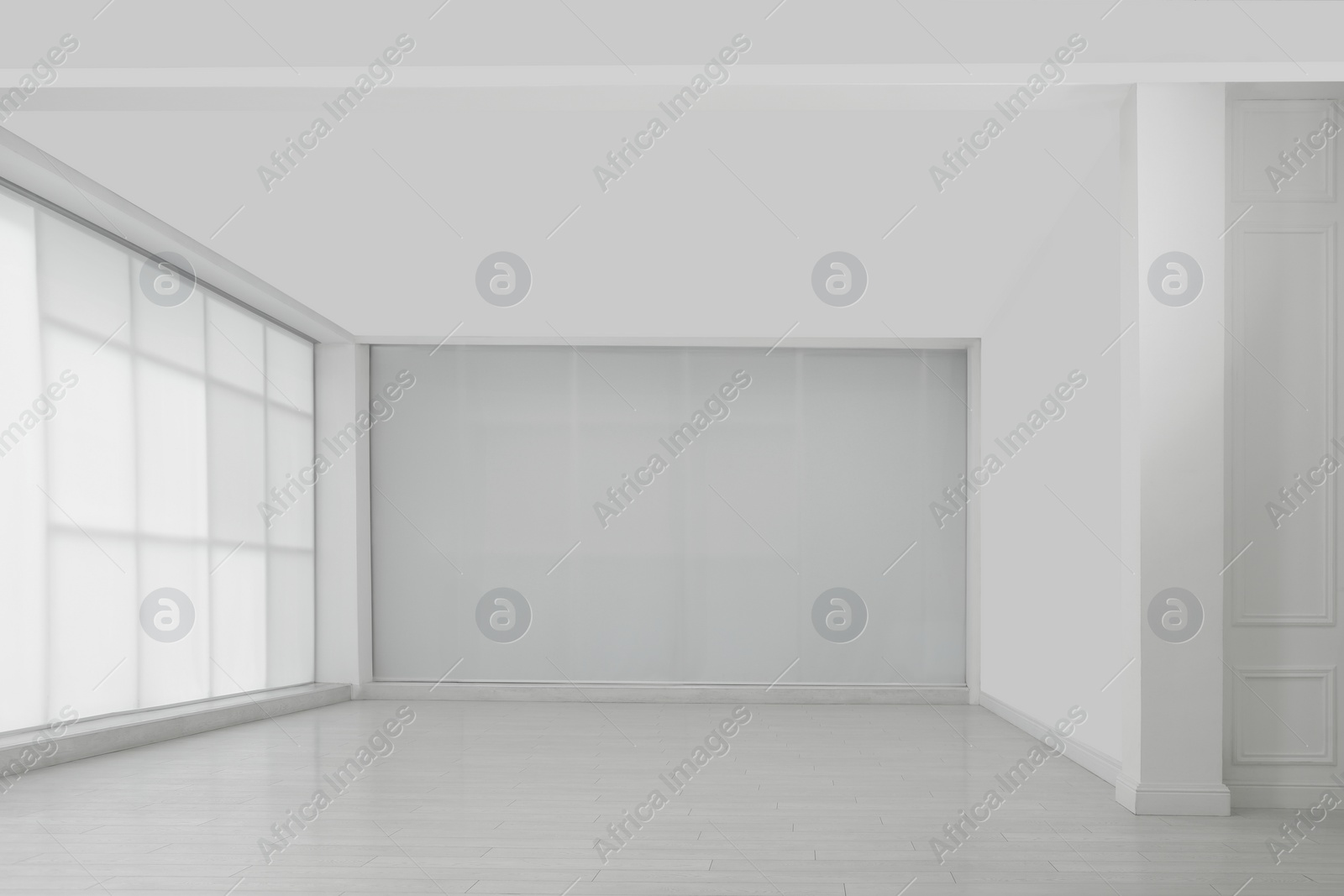 Photo of Empty room with white walls and laminated flooring