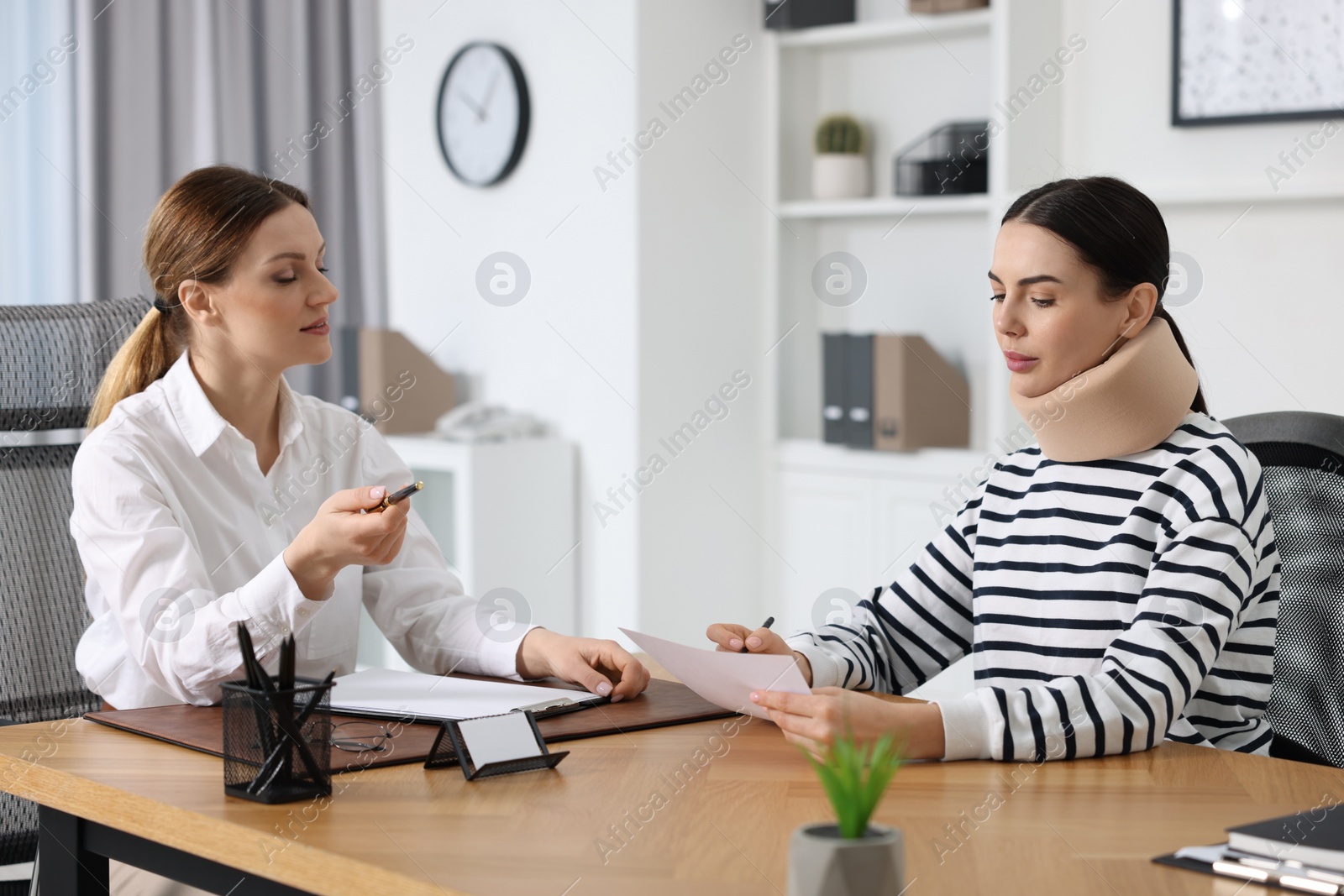 Photo of Injured woman having meeting with lawyer in office