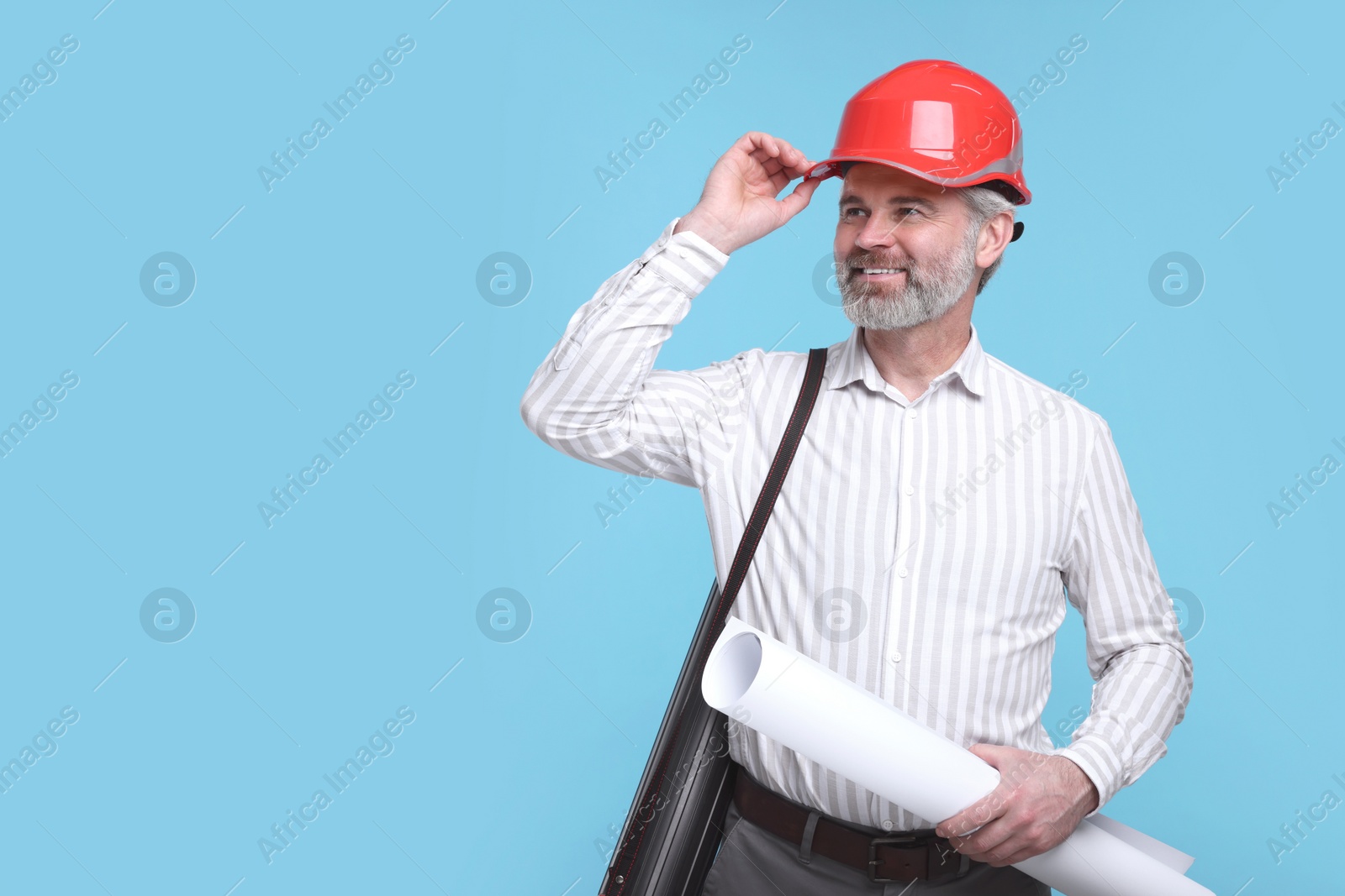 Photo of Architect in hard hat holding draft on light blue background. Space for text