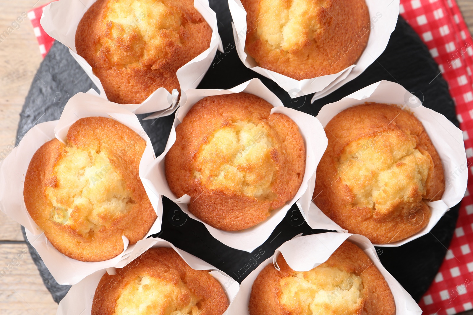 Photo of Delicious sweet muffins on wooden table, top view