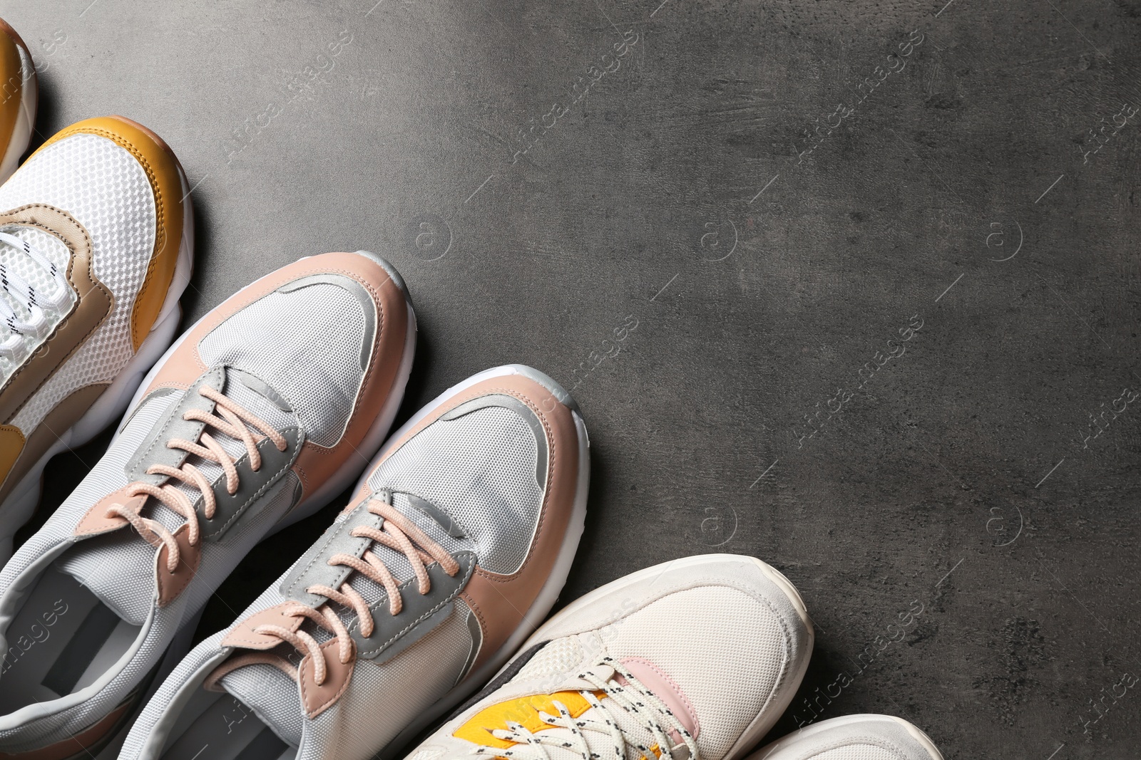 Photo of Flat lay composition with sneakers and space for text on grey background. Stylish shoes