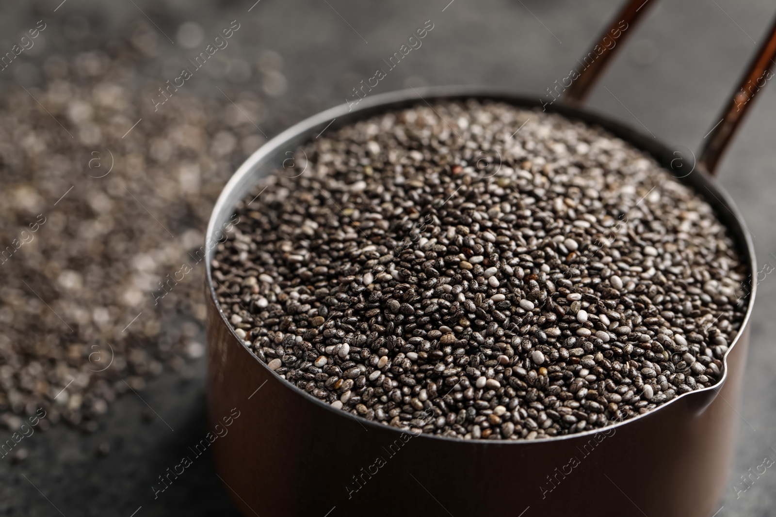 Photo of Saucepan of chia seeds on table, closeup