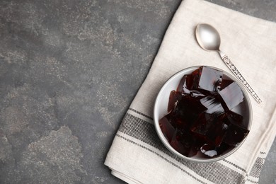 Delicious grass jelly cubes on grey table, flat lay. Space for text