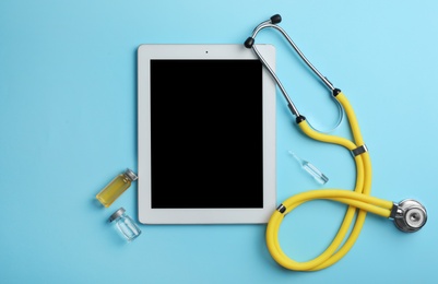Photo of Tablet with space for text, vials and stethoscope on color background, flat lay. Medical items