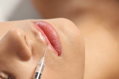Photo of Young woman getting lips injection, closeup. Cosmetic surgery