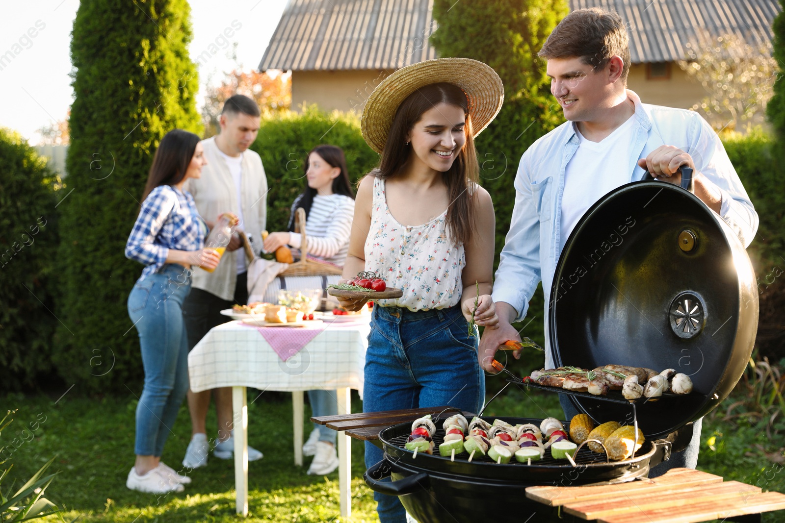 Photo of Group of friends having barbecue party outdoors