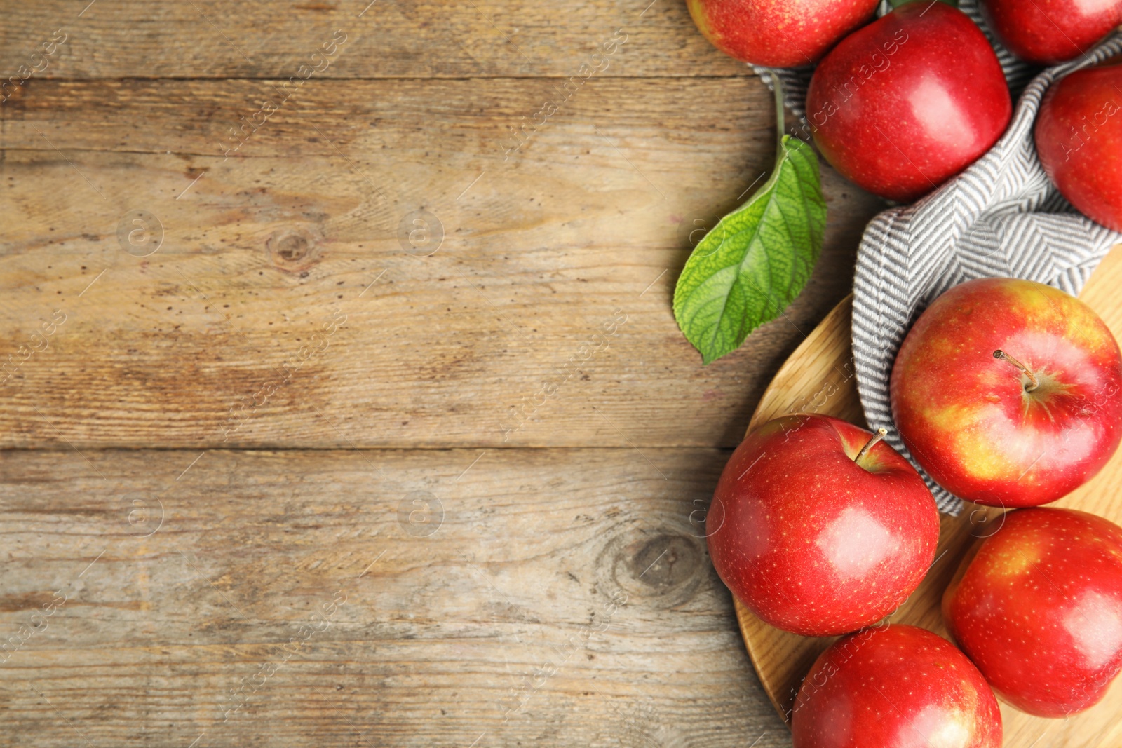 Photo of Ripe juicy red apples on wooden background, flat lay. Space for text