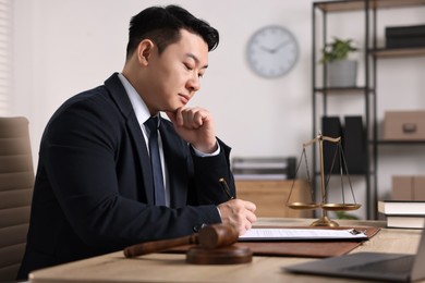 Notary writing notes at wooden table in office