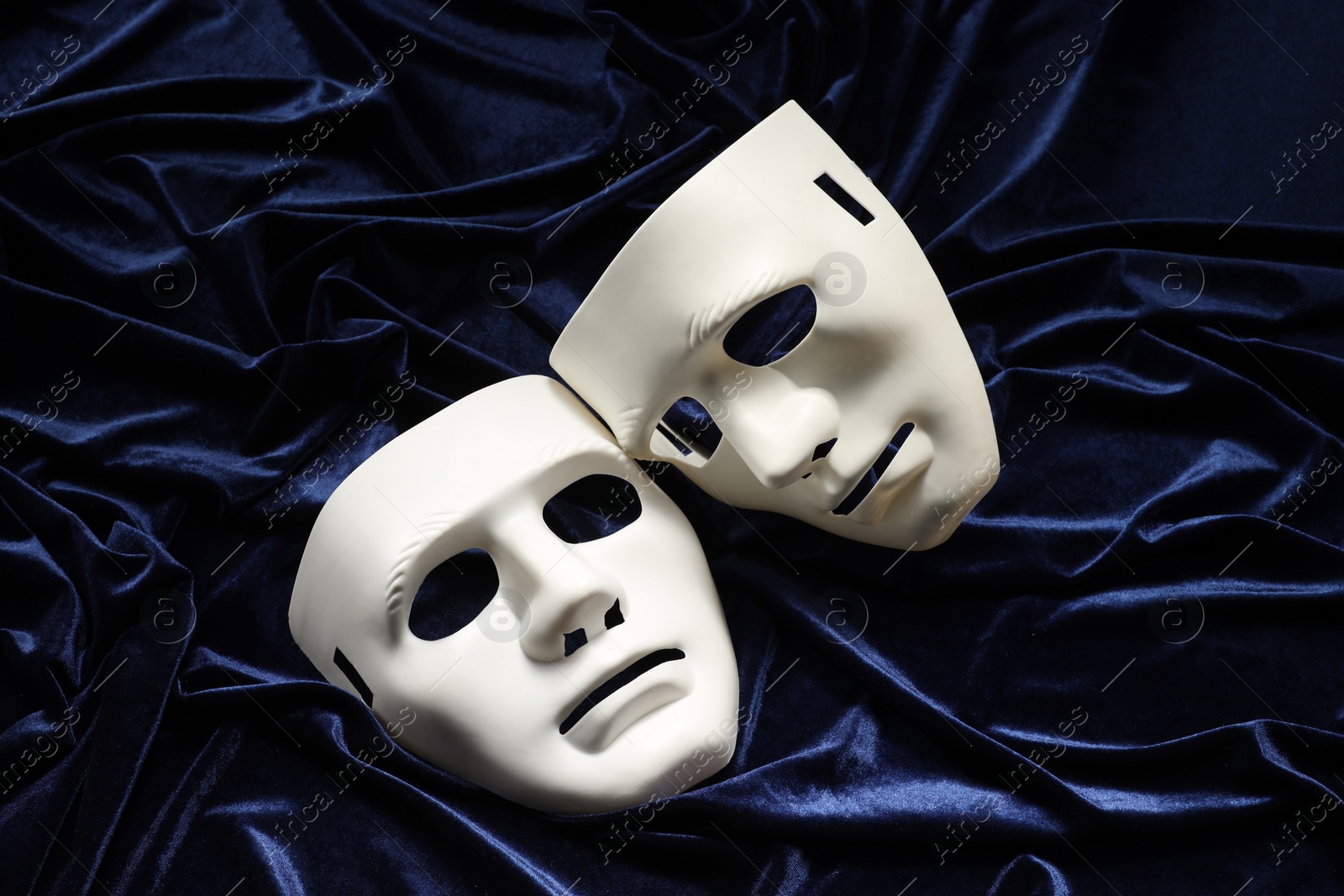 Photo of Theater arts. White masks on blue fabric, above view