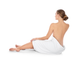 Photo of Young woman with soft towel sitting on white background